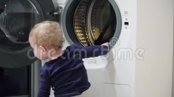 一岁男孩在家里看洗衣机家用电器问题小男孩关上洗衣机视频的预览图