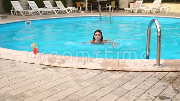 女孩在旅馆的游泳池里游泳视频的预览图
