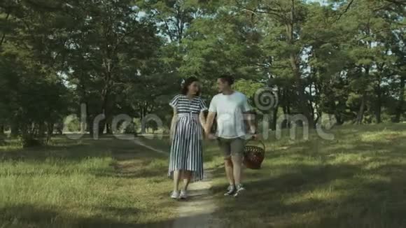 在公园的小径上散步的快乐怀孕夫妇视频的预览图
