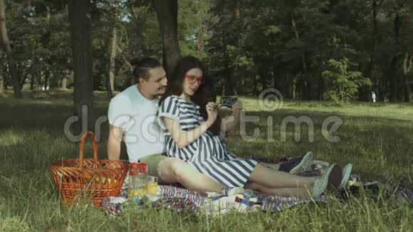 无忧无虑的孕妇情侣在大自然中自拍视频的预览图