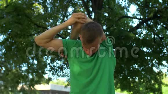 健康的运动员在公园伸展手臂和脖子视频的预览图