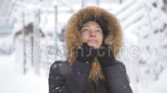 快乐的女人站在雪地下微笑视频的预览图
