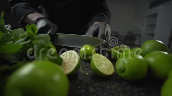 厨师用锋利的大刀把熟透了的石灰切在黑岩石菜桌上由莫吉托新鲜水果健康食品制成视频的预览图