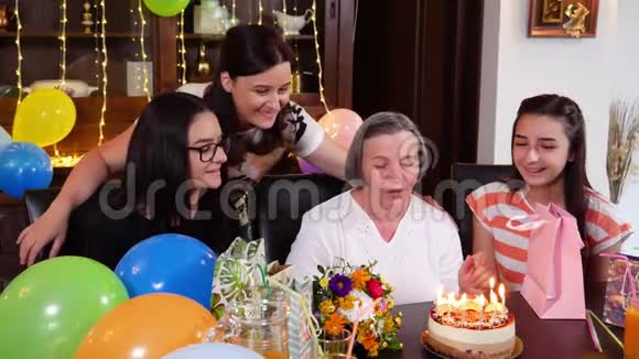 老母亲带着女儿和孙女在生日蛋糕上吹蜡烛视频的预览图