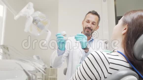 成熟的男牙医教病人牙齿护理持牙模式视频的预览图