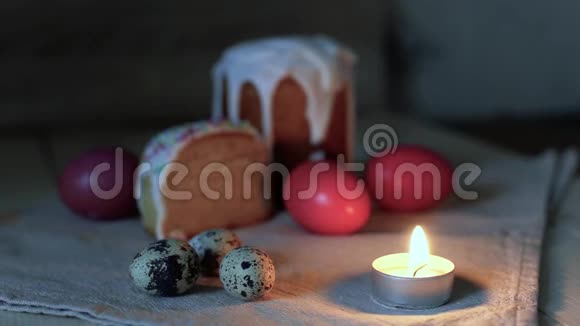 贺卡的背景特写燃烧的蜡烛背景中五颜六色的复活节彩蛋和切成两半的复活节蛋糕视频的预览图