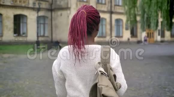 年轻的非洲女学生上大学的动人镜头背着背包和粉色长发的迷人女人视频的预览图