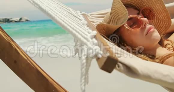 4k海滩吊床上放松的白人妇女侧视图视频的预览图