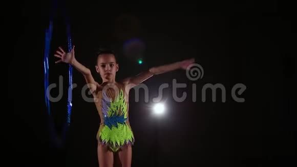 苗条可爱迷人的小女孩运动员身着鲜艳多彩的泳装表演艺术体操元素视频的预览图