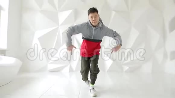 酷酷的霹雳舞者在白色工作室的地板上表演硬舞步视频的预览图