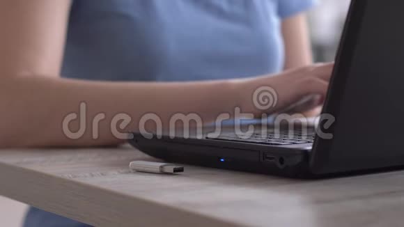 女自由职业者将一张闪存卡插入笔记本电脑在键盘上打字双手合拢视频的预览图