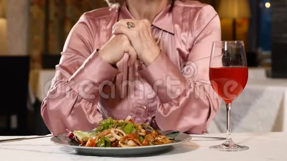 无法辨认的高级女人在感情上交谈退休的女人坐在餐馆里吃蔬菜沙拉和一杯视频的预览图
