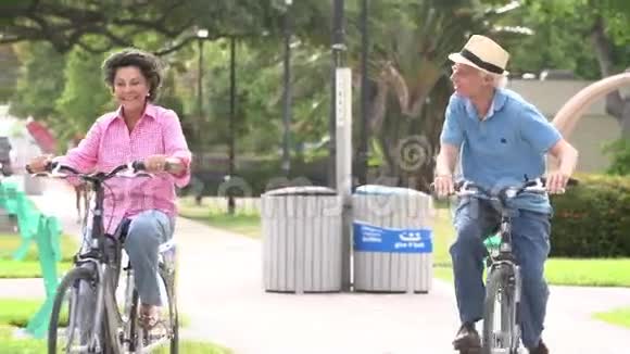 高级夫妇在公园骑自行车的慢动作序列视频的预览图
