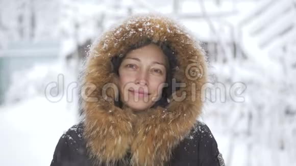 快乐的女人站在雪地下微笑视频的预览图