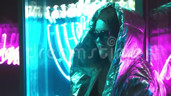 千禧年酷现代漂亮的女孩吸烟附近发光的霓虹灯墙晚上神秘的嬉皮士美丽美丽视频的预览图