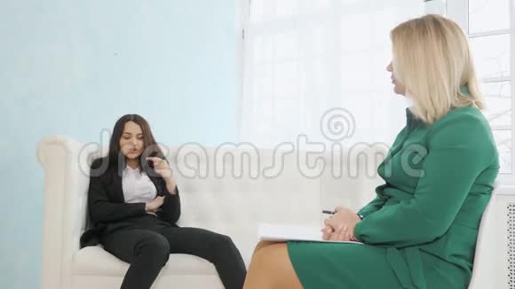 女商人坐在沙发上与女心理学家交谈视频的预览图