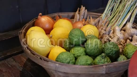 篮子里有水果和蔬菜在靠近木墙的地板上放置各种柠檬和蔬菜的编织篮子视频的预览图