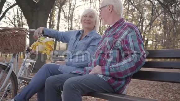 快乐的白种人成熟的夫妇在阳光下坐在长凳上聊天高级欧洲家庭支出视频的预览图