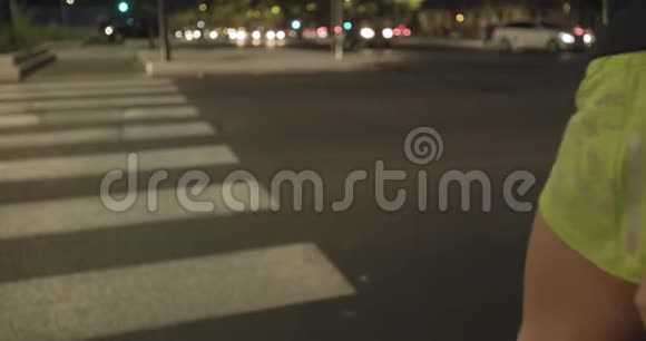 穿健身服的妇女在斑马线上跑步后视图夏夜工业绿城城市视频的预览图
