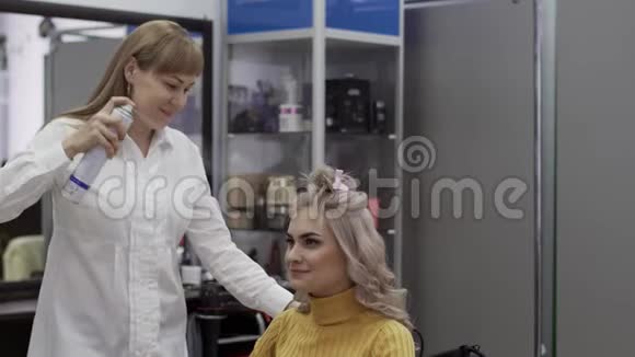 女理发师给她漂亮的女客户喷发型视频的预览图