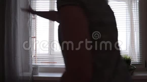 一个女人的剪影在家里关上了一扇灰色透明的窗帘视频的预览图