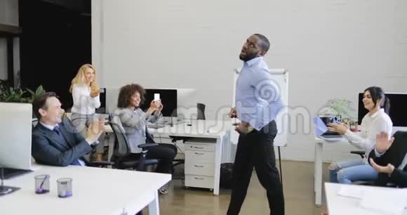 非裔美国商人在现代同事间跳舞欢呼商务人士小组休息视频的预览图