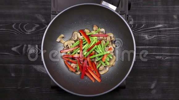 蔬菜与辣椒和大蒜芽和切片蘑菇与鸡柳炒在炒锅做香菜视频的预览图