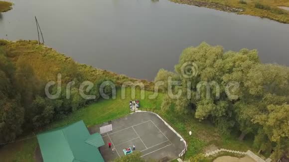 夏季白天大湖和村庄房屋被绿树和小山包围库存数据视频的预览图
