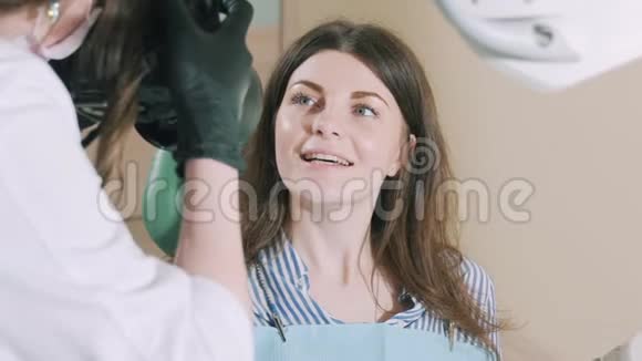牙医为病人做完工作后微笑拍照专家治好了那个女孩牙齿并采取了视频的预览图