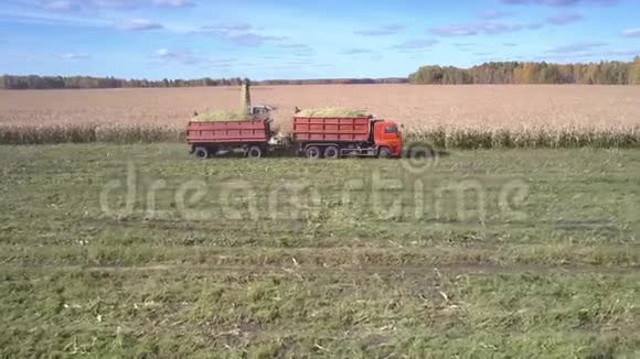 上侧景现代收割机与卡车收集玉米团视频的预览图