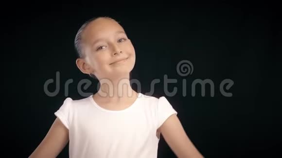 快乐的少年女孩穿着白色裙子在黑色背景下跳舞视频的预览图