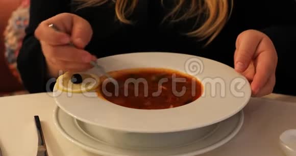 酸奶油用勺子混合在汤碗里视频的预览图