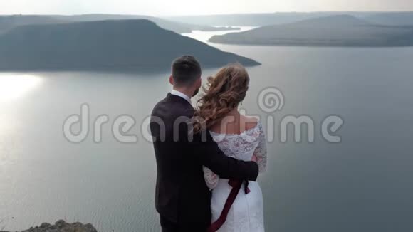 一对神奇而神秘的夫妇从悬崖上眺望海岸视频的预览图