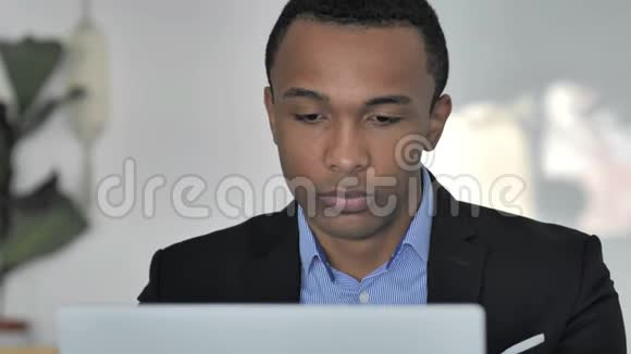 近距离接触在笔记本电脑上工作的休闲非裔美国商人视频的预览图