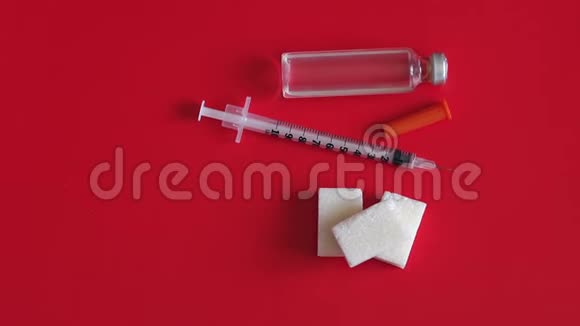 胰岛素注射器无盖和精制糖在红色背景上特写视频的预览图
