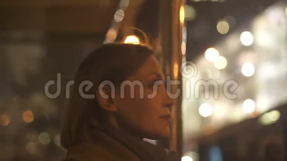 站在公交车站等车照明的成年女士视频的预览图