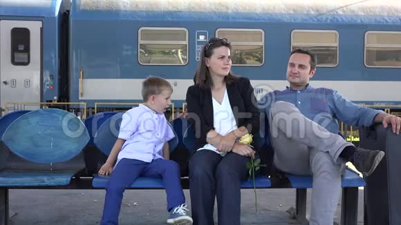 母亲父亲和孩子在火车站等候家庭之旅愉快视频的预览图