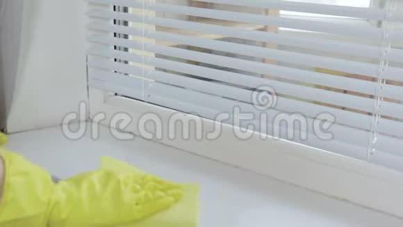 女人用黄胶手套用掸子洗窗台视频的预览图