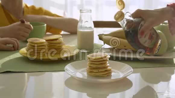 妈妈给两个男孩煎煎饼男孩们正在吃早餐视频的预览图