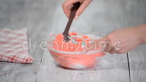 糖果商搅拌粉红色奶油做蛋糕视频的预览图