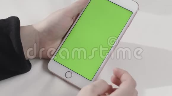 手持触摸绿色屏幕智能手机在白色背景库存录像手敲击带有色度的手机视频的预览图