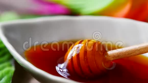 从叶形碗中的蜂蜜勺中倒出视频的预览图