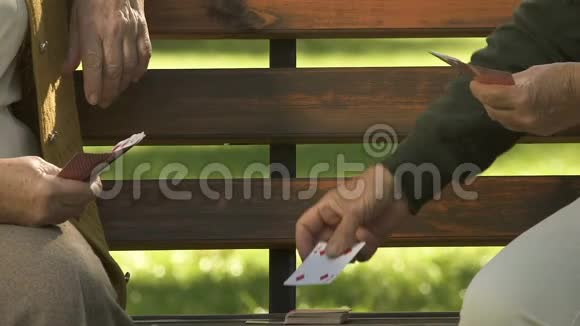 两名女性退休者在公园长椅上打牌退休爱好友谊乐趣视频的预览图