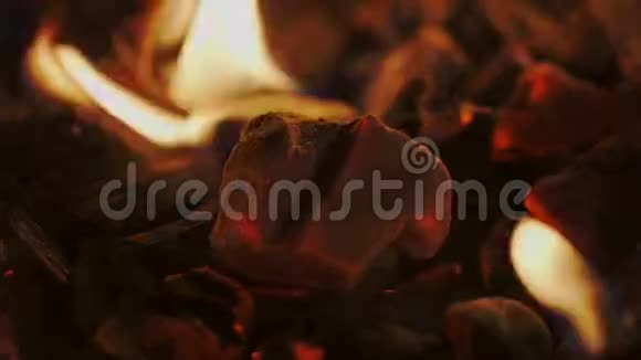 在黑暗中燃烧的木炭和火焰红色摄像机的特写镜头视频的预览图