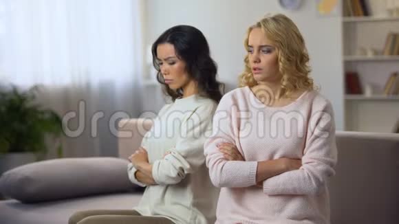 两个女朋友分别坐在家里的沙发上吵架后生气了视频的预览图
