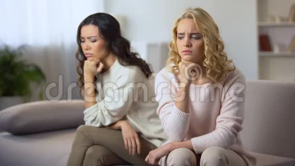 两个生气的年轻女子坐在沙发上担心和最好的朋友吵架视频的预览图
