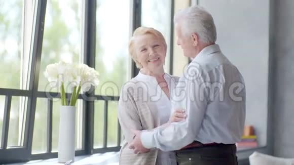 美丽的老妇人看着相机爱和幸福的夫妻在现代公寓交谈视频的预览图
