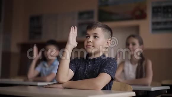 快乐的小学生男孩和女孩学习孩子们举起手来视频的预览图