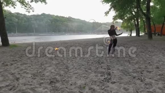 自信苗条的女人跳舞表演一个火球站在沙滩上的表演熟练的射击艺术家表现出熟练视频的预览图