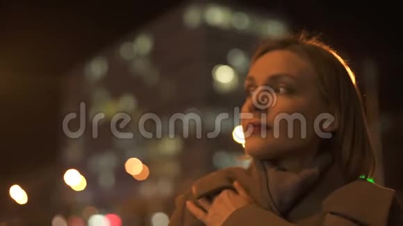 女人等着她的男朋友环顾街道寒冷的秋天天气视频的预览图